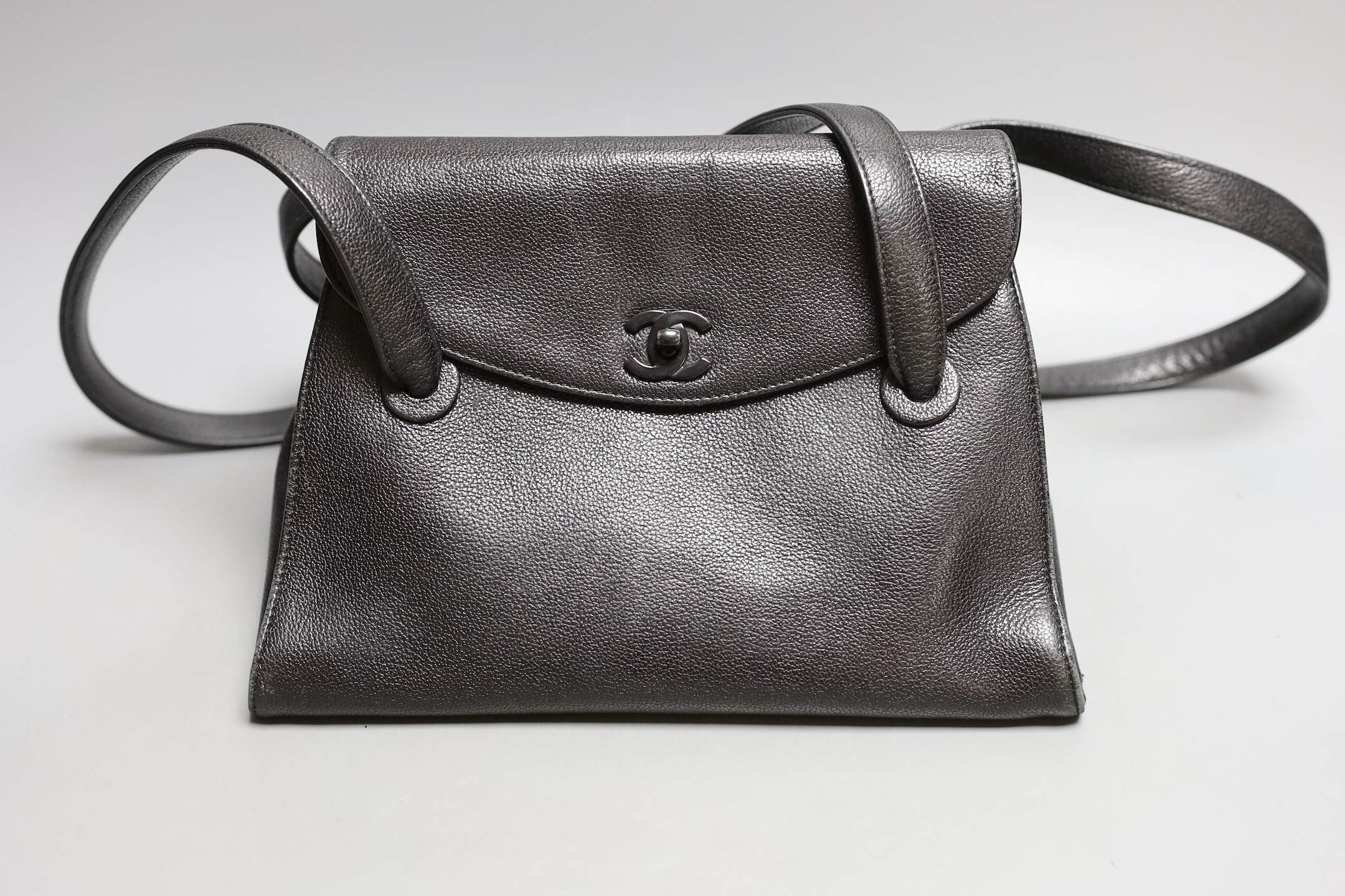 A black Chanel shoulder bag with two straps and Chanel logo lock